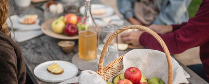 Un cestino con mele su un tavolo per il picnic